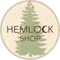 The company's name, HEMLOCK SHOP, in brown letters lays over a green tree in the middle of a circular, brown and beige dreamcatcher.